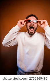 Man pulling up red sunglasses with surprised expression and open mouth