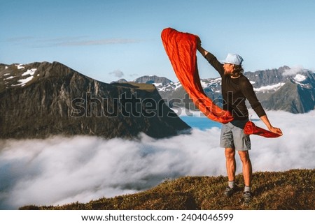 Man pulling sleeping bag out of its cover hiking camping gear active travel vacations in mountains outdoor, traveler exploring Norway adventure sustainable tourism 