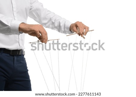 Man pulling strings of puppet on white background, closeup