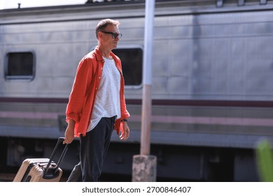 Man pulling a suitcase next to a train, embarking on a journey or vacation