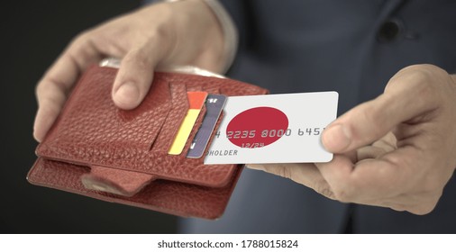 Man Pulls Plastic Bank Card With Flag Of Japan Out Of His Wallet, Fictional Card Number