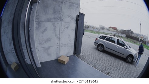 Man Pulls Up in Silver Car. Courier Retrieves Large Parcel, and Carelessly Throws it Onto Porch. Negligent Delivery Captured by Smart Doorbell Camera. Concept of Poor Service and Property Security.