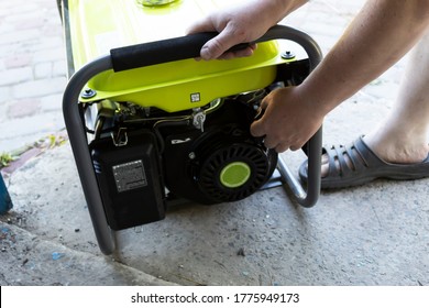 A man pulls the starter cord to start the generator.