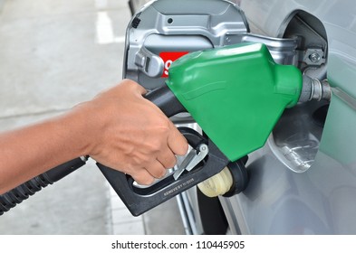 A Man Pumping Gas In To The Tank