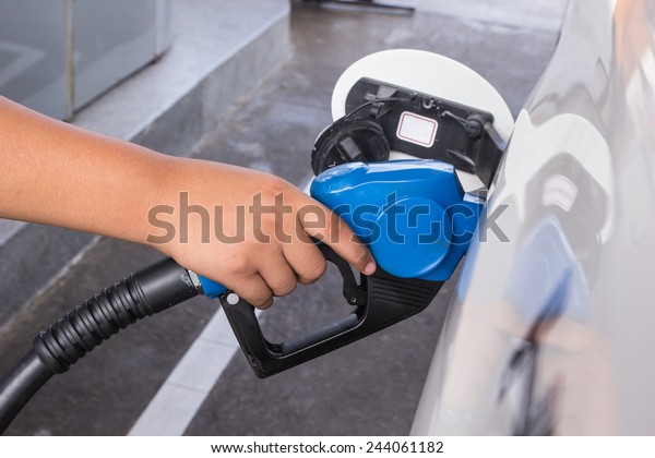 A man pumping gas in to\
the tank
