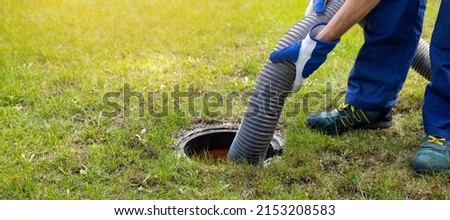 man pumping out house septic tank. drain and sewage cleaning service. copy space