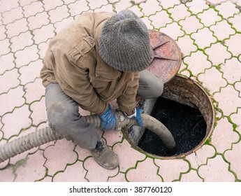 Man Pumping Sewage From The Hole