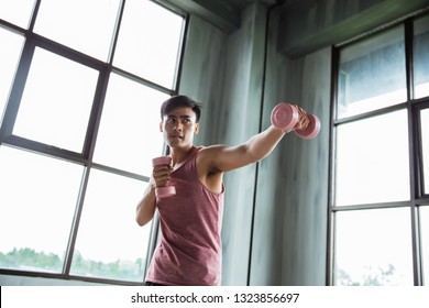 Man Punching And Holding Dumbell For Exercising Boxing Indoor