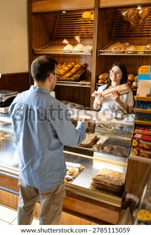 Man purchasing artisanal bread from friendly baker, enjoying local experience in spain