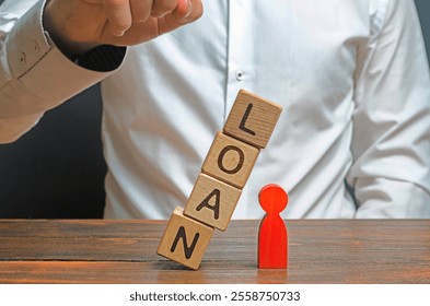 Man pushes downs a cube tower with the word Loan on the red man figure. Lack of protection for vulnerable groups of the population. Debt pit. Harassment of the borrower by collectors. Threat of life