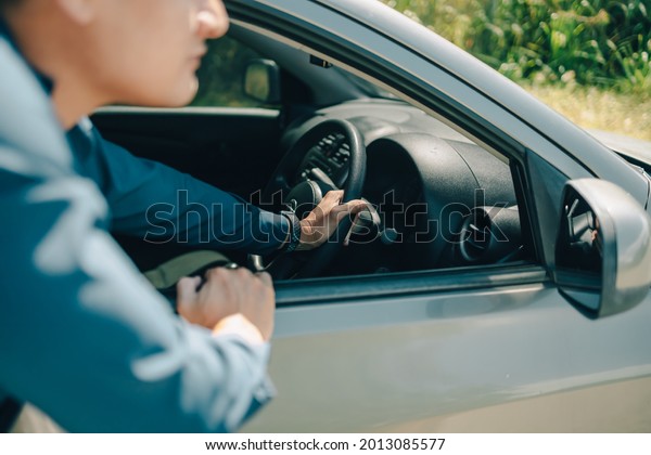 Man pushing a\
broken car breakdown and hands control steering wheel on the road\
hot day. Car broken\
concept.