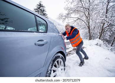 Man Pushing Car In Snow