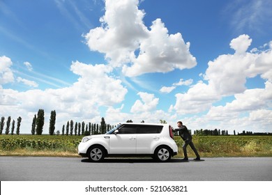 Man Pushing Damaged Car