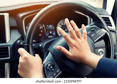 man pushing horn while driving sitting of a steering wheel press car, honking sound to warn other people in traffic concept.