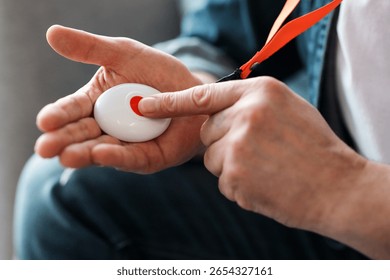 Man pushing panic button on emergency equipment for elderly people