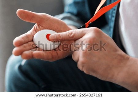 Man pushing panic button on emergency equipment for elderly people