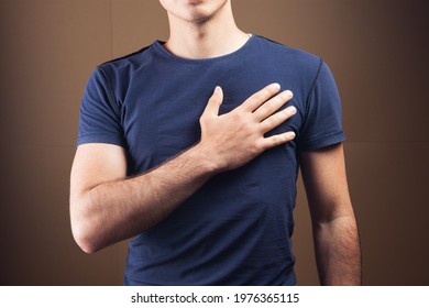 Man Put Hand On Heart On Brown Background