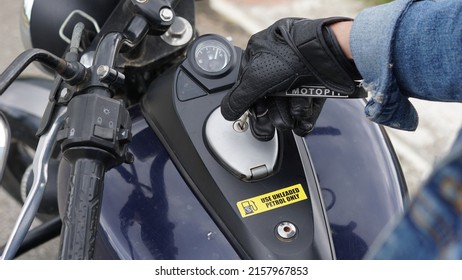 A man put the key to motocycle tank