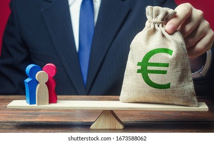 Man Puts Euro Money Bag On Scales With Family Figures. Charitable Donations, Invest In Human Capital. Social Assistance, Financial Support For Who In Need, Vulnerable Populations. Help Aid Migrants