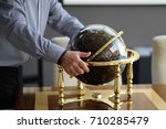 A man puts the globe on a table in a business office