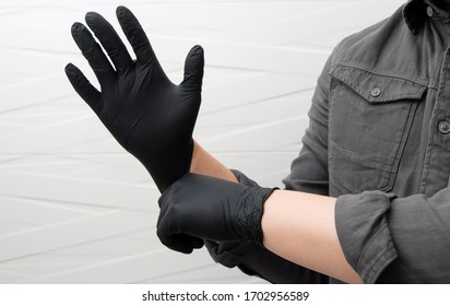 Man Puts On Black Nitrile Medical Gloves