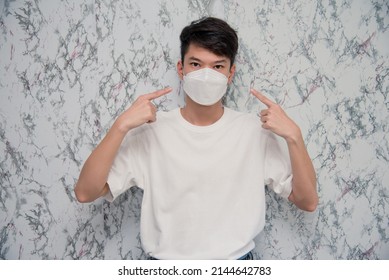 Man Puts On A Face Mask Elegant Man Wearing A Mouth Protection To Prevent Getting Sick At Work Or On The Way To Work  Isolated On White Background ,pandemic And Social Distancing Concept.Covid-19