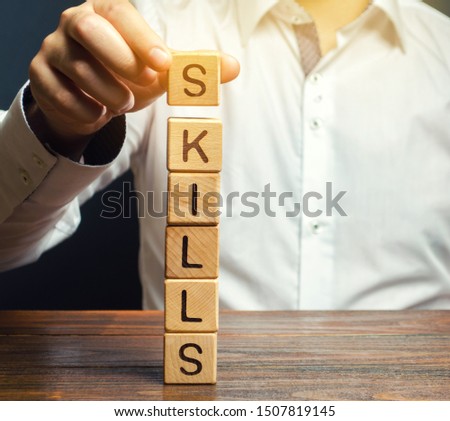 A man puts wooden blocks with the word Skills. Knowledge and skill. Self improvement. Education concept. Training. Leadership skills. Human abilities