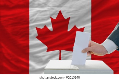 Man Putting Ballot In A Box During Elections In Canada