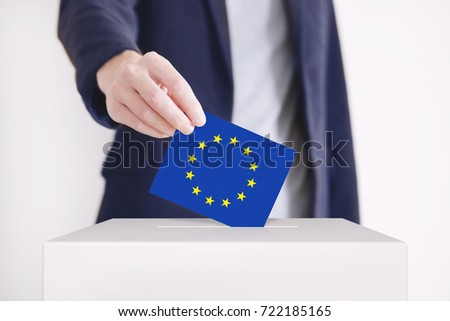Man putting a ballot with European Union flag into a voting box.