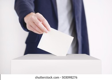 Man Putting A Ballot Into A Voting Box.