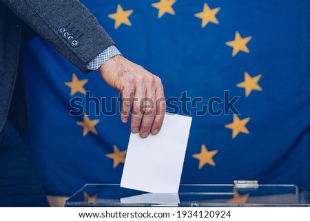 Man putting a ballot into a voting box - European Union.