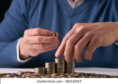 Man putting coins on stack with holding money, Concept business, finance, money saving - Shutterstock ID 584142019