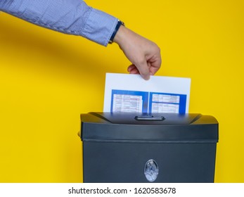 A Man Putting Confidential Documents Into A Paper Shredder