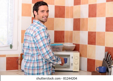 Man Putting Cup In Microwave