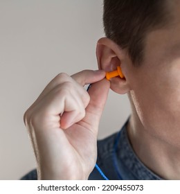 Man Putting Earplugs Into Ear.