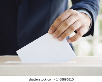Man putting an empty ballot in election box