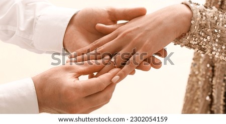 Man putting engagement ring on woman's finger, closeup