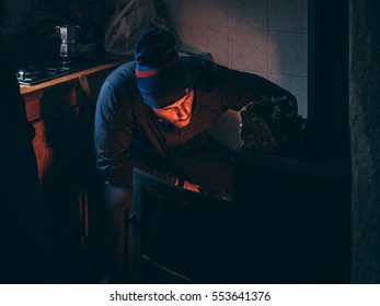 Man putting firewood into wood stove - Powered by Shutterstock