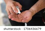 man putting hand sanitizer on his hands