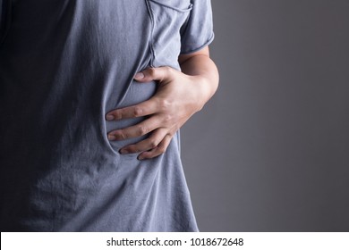 Man Putting His Hands For Belly Or Stomach Ache On Grey Background