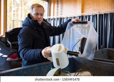 A man putting old appliances into dumpster in sorting centre for safe disposal and recycling - Powered by Shutterstock