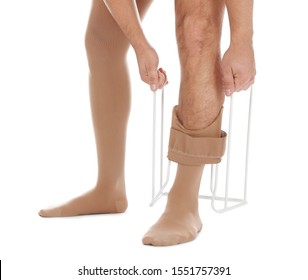 Man Putting On Compression Garment With Stocking Donner Against White Background, Closeup