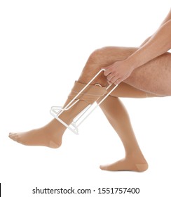 Man Putting On Compression Garment With Stocking Donner Against White Background, Closeup