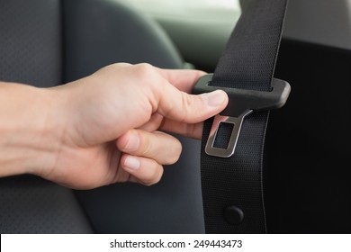 Man Putting On His Seat Belt In His Car