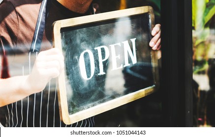 Man putting on shop open sign