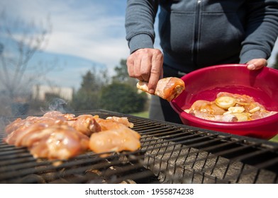 Man Putting The RAW Marinated Chicken On A Hot BBQ Grill, Concept Of A Grilling Meat