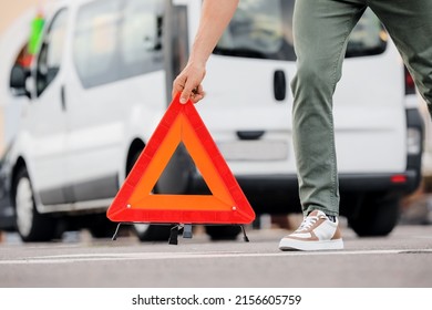 Man Putting Red Emergency Stop Sign On Road