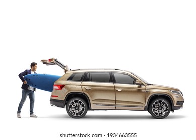 Man putting a surfboard in the trunk of a SUV isolated on white background