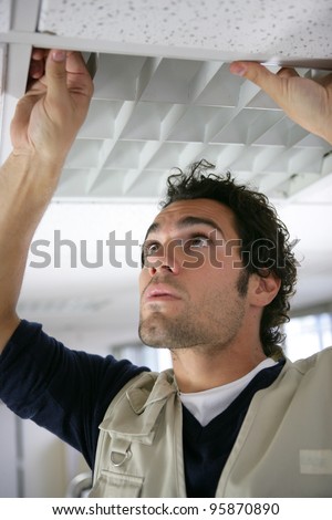 Man putting up a suspended ceiling