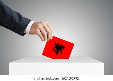 Man Putting A Voting Ballot Into A Box With Albanian Flag.